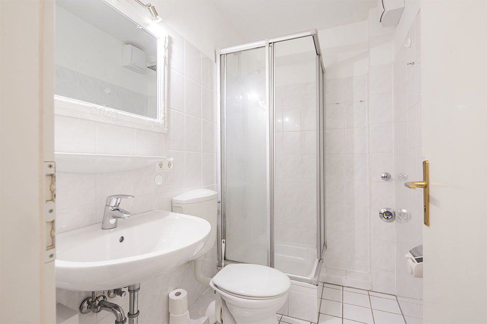 Duschbad im Appartement der Pension Schmidt Appartement  mit Dusche, Waschbecken und WC